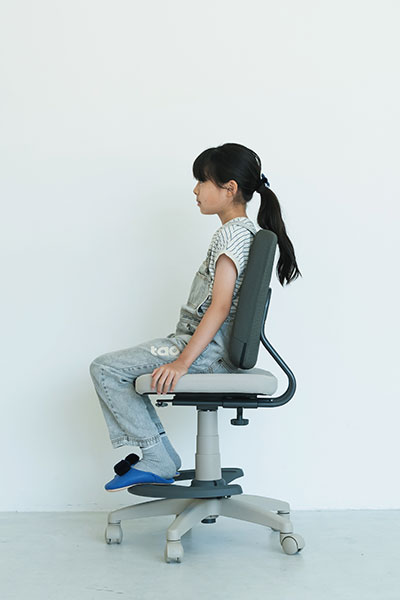 Minoto ミノト チェア 体格に合わせたアジャスタブルな機能 身長132cmの子どもが座っている様子